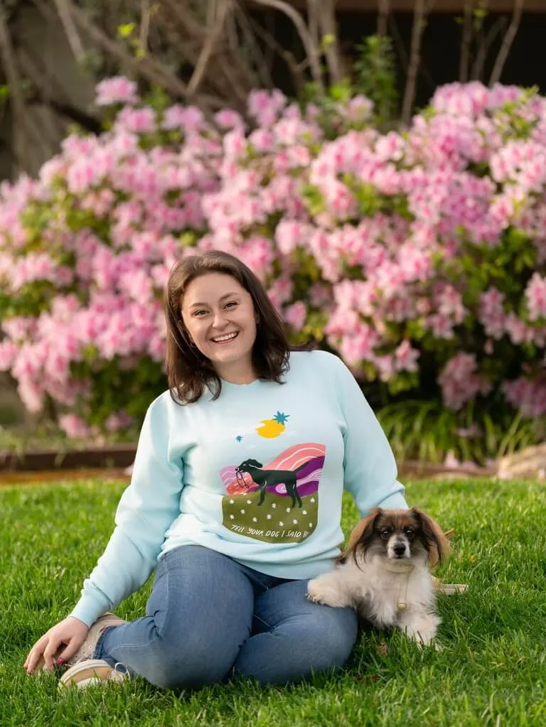 Ruthie's owner sitting in the grass with Ruthie, the rescued puppy featured in this testimonial video